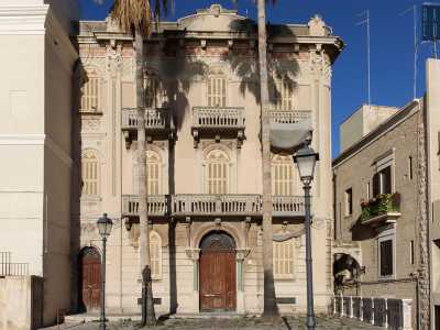 L'edificio, dai colori grigio e rosa, mescola diversi generi architettonici...